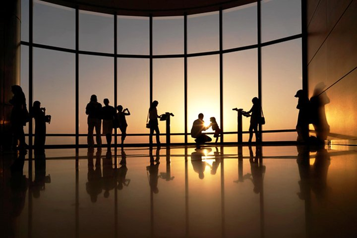 Experience the breathtaking sunrise from level 124 of Burj Khalifa as travelers marvel at Dubai's skyline while savoring morning treats at The Café below.